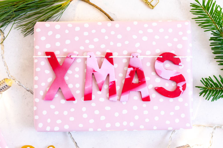Geschenke verpacken - Weihnachtsgeschenke beschriften mit Fimo. Diese tolle DIY Geschenkidee verwandelt deine Geschenke im Handumdrehen in wunderschöne Unikate. Dieses DIY eignet sich perfekt zum Basteln mit Kindern an Weihnachten: die Schritt für Schritt Anleitung findest du auf dem MrsBerry.de Blog