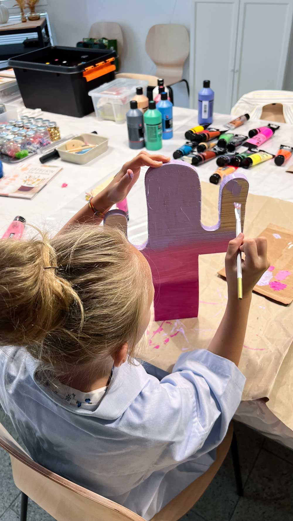 Malkurs Kinder Köln - Kind bemalt einen Holzkaktus mit Acrylfarben um Kreatickurs.