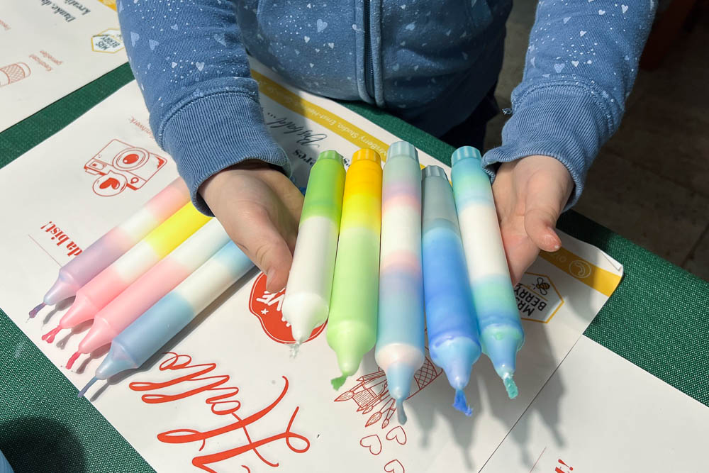 Kind hält selbst gestaltete Dip Dye Kerzen beim Kindergeburtstag Workshop in Köln