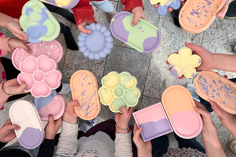 Kinder halten fertige Keramik Schmuckschalen beim Kindergeburtstag Workshop in Köln in den Händen