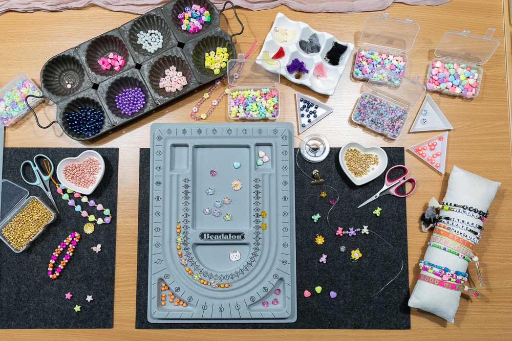 Arbeitsplatz mit Perlenbrett und Auswahl an Perlen beim Schmuckparty Kindergeburtstag in Köln
