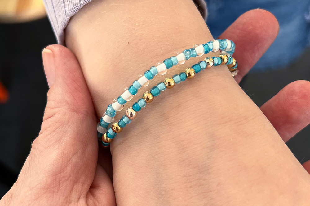 Mehrere selbstgemachte Armbänder am Handgelenk beim Kindergeburtstag Schmuckparty in Köln