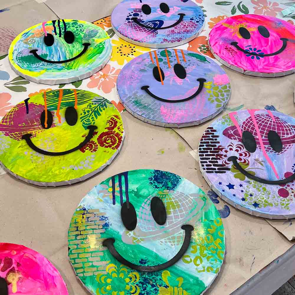 Bunte Happy Face Art Kunstwerke auf runden Leinwänden, gestaltet von Kindern bei einem kreativen Kindergeburtstag im MrsBerry Studio bei Köln.