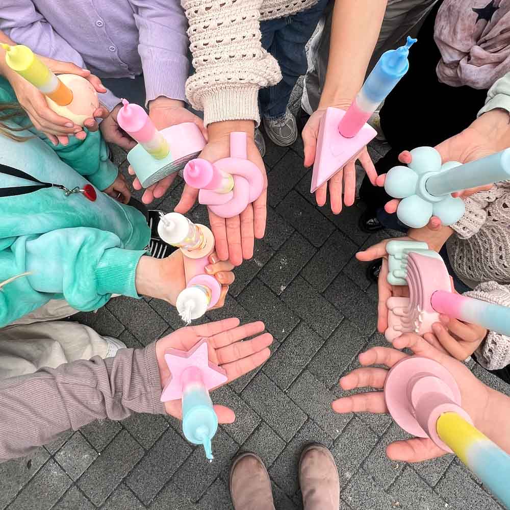Kinder halten selbst gegossene Kerzenhalter mit bunt gefärbten Dip Dye Kerzen bei einem kreativen Kindergeburtstag im MrsBerry Studio bei Köln.